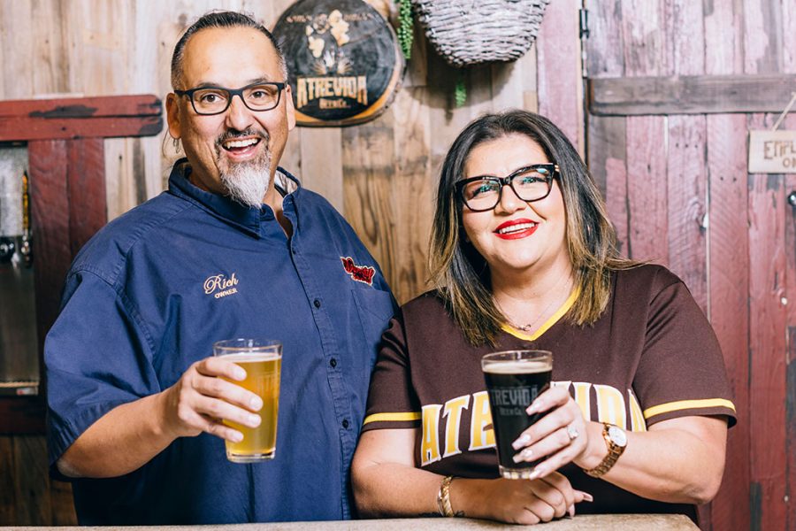 Atrevida founders holding beer behind brewery