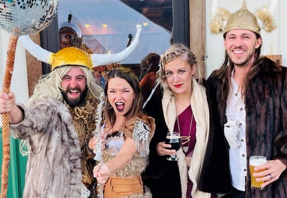 costumed young people posing outside mountain brewery