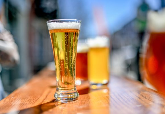 pilsner beer on sunny patio with ales in background