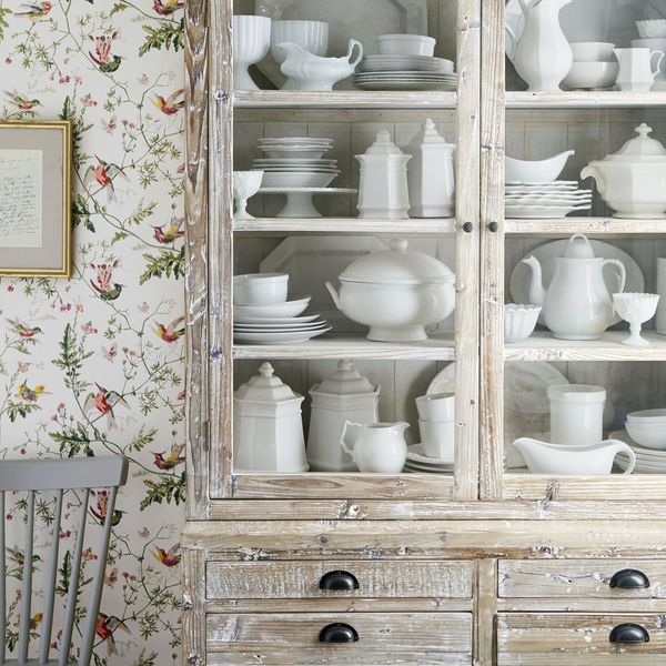 Avec son aspect patiné, la vitrine ancienne matche parfaitement dans une cuisine avec un papier peint rétro