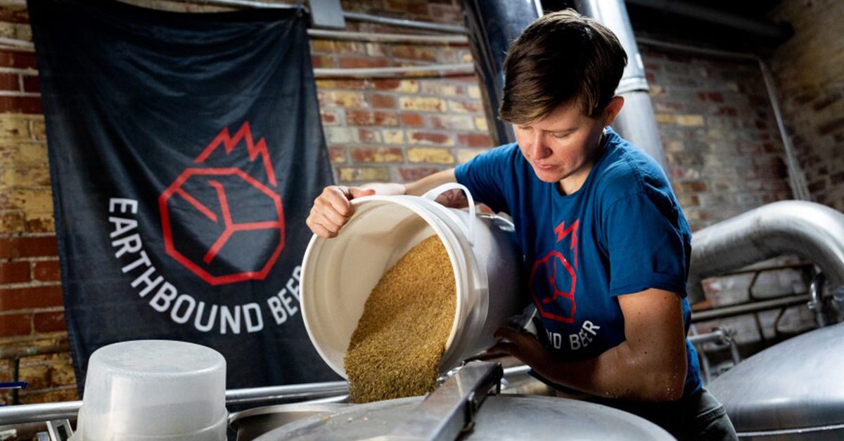 woman pouring grain in brewhouse