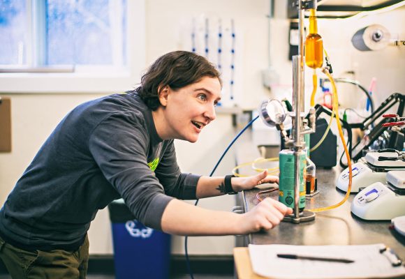 woman working with canned beer in quality lab