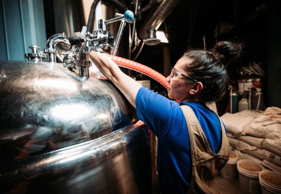 women working at bright tank back of house brewery