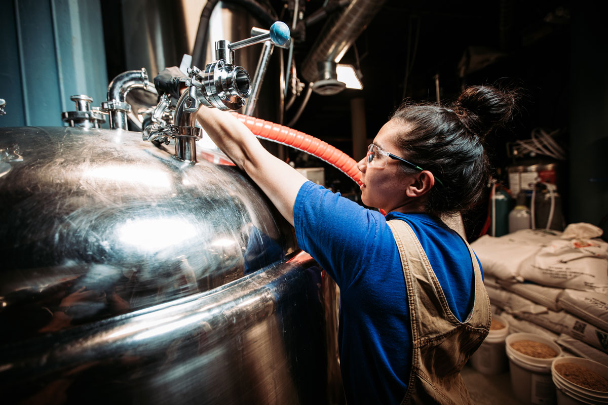 women working at bright tank back of house brewery